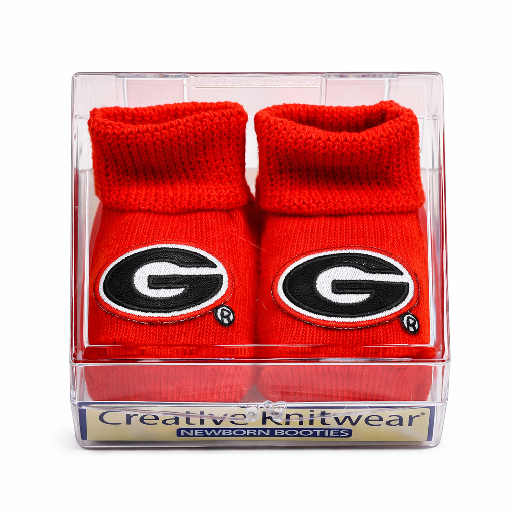 Red baby booties with a logo in a clear packaging box on a white background